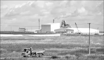  ??  ?? A truck drives past an incinerato­r for nuclear waste left over from the Fukushima nuclear accident.