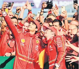  ?? — AFP photo ?? The Ferrari team members celebrate their Australian Grand Prix victory.