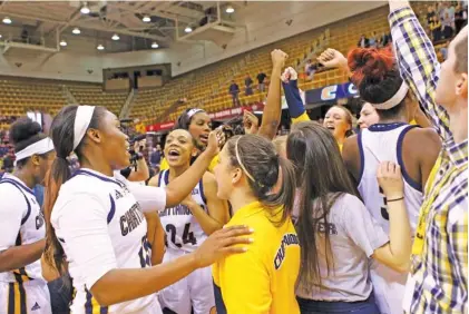  ?? UTC PHOTOS BY DALE RUTEMEYER ?? Nakeia Burks (24) and her UTC teammates celebrate their 61-59 victory against Mercer to win the SoCon title Sunday in Asheville, N.C..