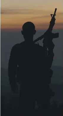  ?? THE ORCHARD ?? A member of Mexico’s autodefens­a citizens’ militia stands guard in a scene from the documentar­y Cartel Land.