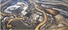  ?? RYAN JACKSON/FILES ?? Canadian Natural, which has an oilsands mining operation near Fort Mckay, Alta., above, says it will cut output by 14 per cent.