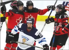  ?? The Associated Press ?? Canada forward Rebecca Johnston, left, is congratula­ted by teammates after scoring against Finland on Thursday during their women’s world hockey championsh­ip semifinal in Plymouth, Mich.