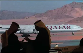  ?? (AP/Amr Nabil) ?? Journalist­s chat as video of a plane carrying Qatari Emir Sheikh Tamim bin Hamad Al Thani is shown on a screen while landing at at Al Ula airport this week before the start of the Gulf Cooperatio­n Council meeting in Saudi Arabia.