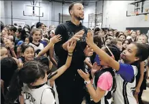  ?? JEFF CHIU/THE ASSOCIATED PRESS ?? Golden State Warriors star Steph Curry greets camp participan­ts after taking a group picture at Ultimate Fieldhouse in Walnut Creek, Calif., earlier this week.