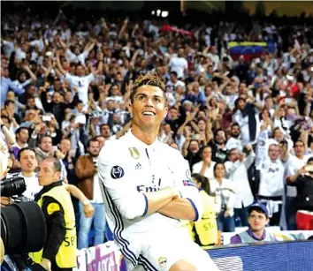  ??  ?? Cristiano Ronaldo sits on the advertisin­g boards to take in his applause at the Bernabeu