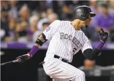  ??  ?? The Rockies’ Carlos Gonzalez watches his three-run triple off Giants relief pitcher Ty Blach in the seventh inning.