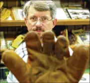  ?? MICHAEL FUENTES / BLOOMBERG ?? Rob Storey holds an old Nokona baseball glove last month at the company factory in Nocona, near Dallas. Storey is executive vice president of the company, which was founded in 1926.