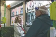  ??  ?? Two commuters wearing face shields travel by tram during lockdown in Melbourne, Australia.