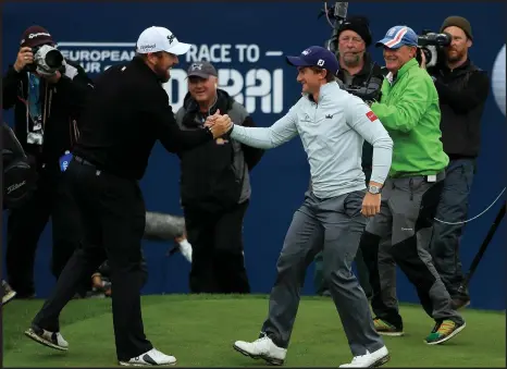  ??  ?? Paul Dunne takes the congratula­tions of his compatriot Shane Lowry after winning the British Masters. Picture: Getty Images