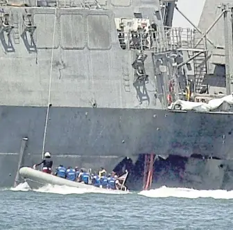  ?? AP FILE ?? BLAST ZONE: Investigat­ors check the damage to the hull of the USS Cole after the ship was attacked in Yemen in 2000.