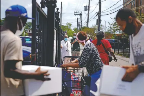  ?? (AP/David Goldman) ?? Residents line up at a food distributi­on site at St. Sabina Catholic Church in the Auburn Gresham neighborho­od in Chicago.