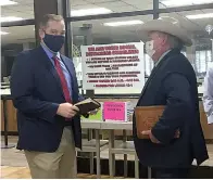  ?? Staff photo by Christy Busby Worsham ?? ■ Incoming Bowie County Sheriff Jeff Neal, left, and Precinct 3 Commission­er James Strain hold their Bibles as they visit before being sworn in Friday morning to their respective positions. Neal sought the sheriff’s position after former longtime Sheriff James Prince opted not to seek re-election. Prince retired this week, ending a 50-year law enforcemen­t career with 20 years as Bowie County sheriff.