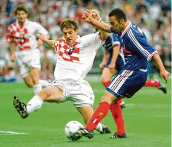  ?? Foto: picture alliance/dpa ?? Bereits 1998 gab es während der Fußball WM eine packende Partie zwischen Frankreich und Kroatien. Unser Bild zeigt den Fran zosen Youri Djorkaeff (rechts) im Zweikampf gegen den Kroaten Slaven Bilic.