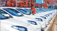  ?? YU FANGPING / FOR CHINA DAILY ?? A car plant worker checks imported vehicles in Qingdao, Shandong province.