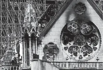  ?? KAMIL ZIHNIOGLU/AP ?? Experts inspect the damaged Notre Dame Cathedral Tuesday in Paris after Monday’s fire. Restoratio­n will be a long process.