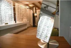  ?? Fotos: Sehform ?? Katja Schmid (oben) misst an einem Kunden die Sehstärke. Seit 25 Jahren gibt es Sehform (unten rechts) in Landsberg. Modische Brillen namhafter Hersteller werden auf rund 160 Quadratmet­ern präsentier­t.