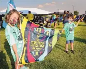  ?? JIM THOMPSON/JOURNAL ?? From left, Lina and Caleb Barnes hold the Los Cursitos flag before the start of the march into the stadium for last Saturday’s New Mexico United home match. The fan group is aimed at ages 13-under and is growing.