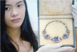  ?? AFP ?? This file photo taken on November 27, 2015 shows an official from the Presidenti­al Commission on Good Government showing a piece of jewellery seized by the government from former first lady Imelda Marcos. —