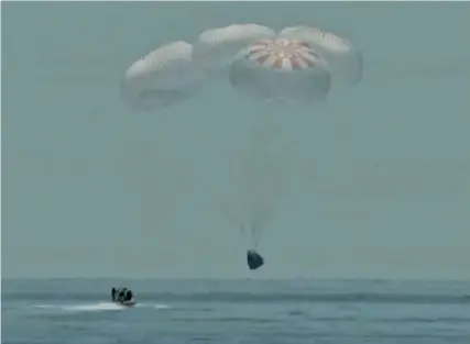  ?? FRAME GRAB FROM NASA TV ?? Crew on a U.S. Navy inflatable craft looks on as the SpaceX capsule splashes down Sunday in the Gulf of Mexico. Astronauts Doug Hurley and Bob Behnken spent a little over two months on the Internatio­nal Space Station.