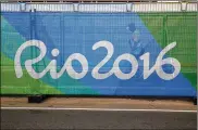  ?? ASSOCIATED PRESS 2016 REBECCA BLACKWELL / ?? A volunteer walked behind a barrier printed with the Rio2016 logo inside Olympic Park during the 2016 Summer Olympics in Rio de Janeiro, Brazil.