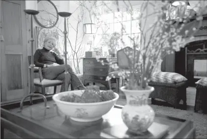  ?? SHNS photos ?? Kaye McWhorter is seen behind a coffee table she purchased for $10 at an estate sale. The McWorter home is filled with thoughtful­ly repurposed, found items and thrift-store bargains. For example, McWhorter applied animal print accents to a chair she...