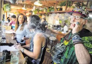  ?? Brian van der Brug Los Angeles Times ?? RICHARD EASTMAN, right, smokes a joint inside the Lowell Cafe on Oct. 1, 2019, opening day for the newly licensed restaurant and cannabis bar in West Hollywood.