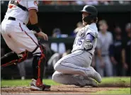  ?? NICK WASS — THE ASSOCIATED PRESS ?? Rockies first baseman Hunter Goodman slides toward home past Orioles catcher James Mccann to score on a ground out by pinch hitter Elias Diaz during the ninth inning of Sunday’s game at Oriole Park at Camden Yards in Baltimore.