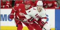  ?? PAUL SANCYA — THE ASSOCIATED PRESS ?? Carolina Hurricanes’ Haydn Fleury, right, skates ahead of Detroit Red Wings’ Dylan Larkin during Detroit’s 2-1loss on Sunday.