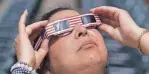  ?? AL GOLDIS/FOR THE LANSING STATE JOURNAL ?? Natalie Harper watches the eclipse on Aug. 21, 2017, at Cooley Law School Stadium in Lansing.