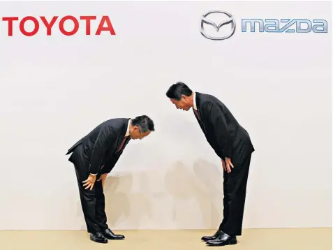  ??  ?? Akio Toyoda, Toyota president, and Masamichi Kogai, his Mazda counterpar­t, bow at a news conference in Tokyo. The car industry in the UK has suffered another set of poor figures