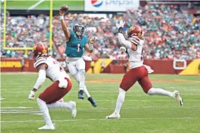  ?? GEOFF BURKE/USA TODAY SPORTS ?? Eagles quarterbac­k Jalen Hurts gets off a pass as the Commanders try to defend it Sunday.