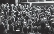  ?? AP ?? People record the reveal of the student iPad at Lane Technical College Prep High School in Chicago on Tuesday.