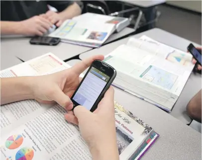  ?? KYE R. LEE, TRIBUNE NEWS SERVICE ?? A teen uses a smartphone in a high school class. At least one middle school in Greater Victoria — Central — has banned the devices from classrooms.