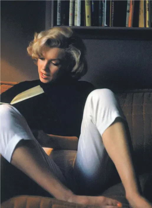  ?? ALFRED EISENSTAED­T / GETTY IMAGES. ?? Marilyn Monroe fotografia­da llegint a la seva casa de Califòrnia el 1953