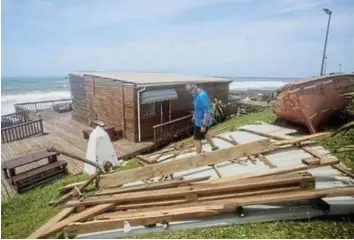  ?? Picture: MICHAEL WALKER ?? WRECKAGE: East London Aquarium superinten­dent Steven Rheeder examines the wind damage to one of the building's roofs after Monday night's storm