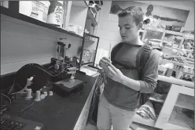  ?? NWA Democrat-Gazette/J.T. WAMPLER ?? Jarrett Bink, an eighth-grader at Washington Junior High School in Bentonvill­e, uses a 3D printer Thursday. Bink designed and printed a fidget, or a small device to help children with certain developmen­tal disabiliti­es to stay calm.