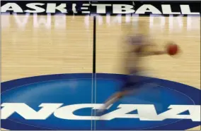  ?? KEITH SRAKOCIC - THE ASSOCIATED PRESS ?? FILE - In this March 14, 2012, file photo, a player runs across the NCAA logo during practice at the NCAA tournament college basketball in Pittsburgh.