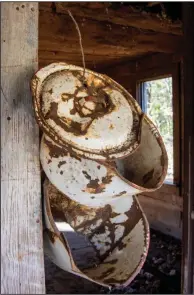  ??  ?? Old pots and lids are strung from a wire on the front porch.