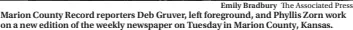  ?? Emily Bradbury The Associated Press ?? Marion County Record reporters Deb Gruver, left foreground, and Phyllis Zorn work on a new edition of the weekly newspaper on Tuesday in Marion County, Kansas.