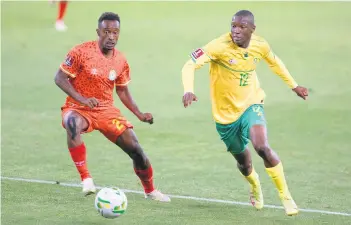  ?? Images /Gallo ?? Shemeles
Nasir Ahmed of Ethiopia and Bongokuhle Hlongwane of South Africa during the 2022 World Cup qualifer match on Tuesday.