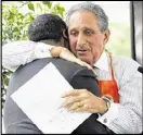  ?? BOB ANDRES / AJC ?? Atlanta Falcons owner Arthur Blank hugs Mayor Kasim Reed at the event where plans for Home Depot Backyard were announced.