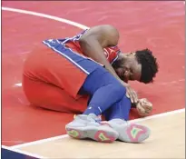  ?? AP photo ?? Sixers center Joel Embiid grimaces after an injury during the second half of Philadelph­ia’s 127101 win over the Washington Wizards on Friday.