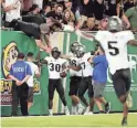  ?? KIM KLEMENT/USA TODAY SPORTS ?? Central Florida running back Greg McCrae (30) is congratula­ted by teammates after scoring a touchdown against South Florida in 2018.