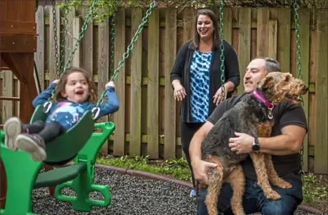  ?? Alexandra Wimley/Post-Gazette ?? Beth Goldstein pushes her daughter, Hannah, on a swing as her husband, Jeremy Goldman, plays with their dog, Penny, on May 14 outside their home in Squirrel Hill.