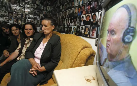  ??  ?? Bosnian Muslim women from Srebrenica, sitting under pictures of victims of the genocide in the town during the 1992-1995 Bosnian war, react as they watch the television broadcast of Ratko Mladic’s court proceeding­s, in Tuzla in 2011. Below, Mladic at...