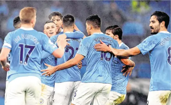  ??  ?? Manchester City players rush to celebrate with goalscorer Phil Foden (centre) last night during their 1-0 victory over Brighton, but UK authoritie­s claim this behaviour is insulting to NHS workers and have asked Premier League stars to refrain from ‘unnecessar­y physical contact’ –