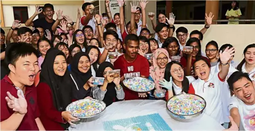  ??  ?? A colourful celebratio­n: USM students showing off their finished product. Around 100 students got together to make the glutinous rice balls to celebrate the Winter Solstice Festival.