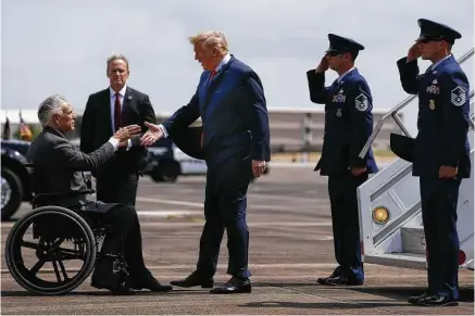  ?? Michael Ciaglo / Houston Chronicle ?? President Donald Trump is met by Gov. Greg Abbott as he arrives at Ellington Field on Thursday. The president was in Houston for a fundraiser and to meet with community leaders and families from Santa Fe. STORY ON PAGE A3