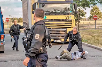  ?? AFP ?? Operativo. Policías franceses detienen, el jueves en Calais, a un inmigrante que quería cruzar el Eurotúnel.