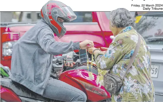  ?? PhotograPh­s by yummie DingDing for the Daily tribune @tribunephl_yumi ?? Random act of kindness a motorcycle driver stops to buy sampaguita garlands from an elderly vendor along Quirino avenue, manila on a drizzling thursday.